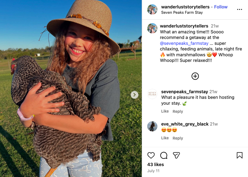 A photo of the Wanderlust Storytellers family’s youngest child holding a chicken while staying at Seven Peaks Farmstay 