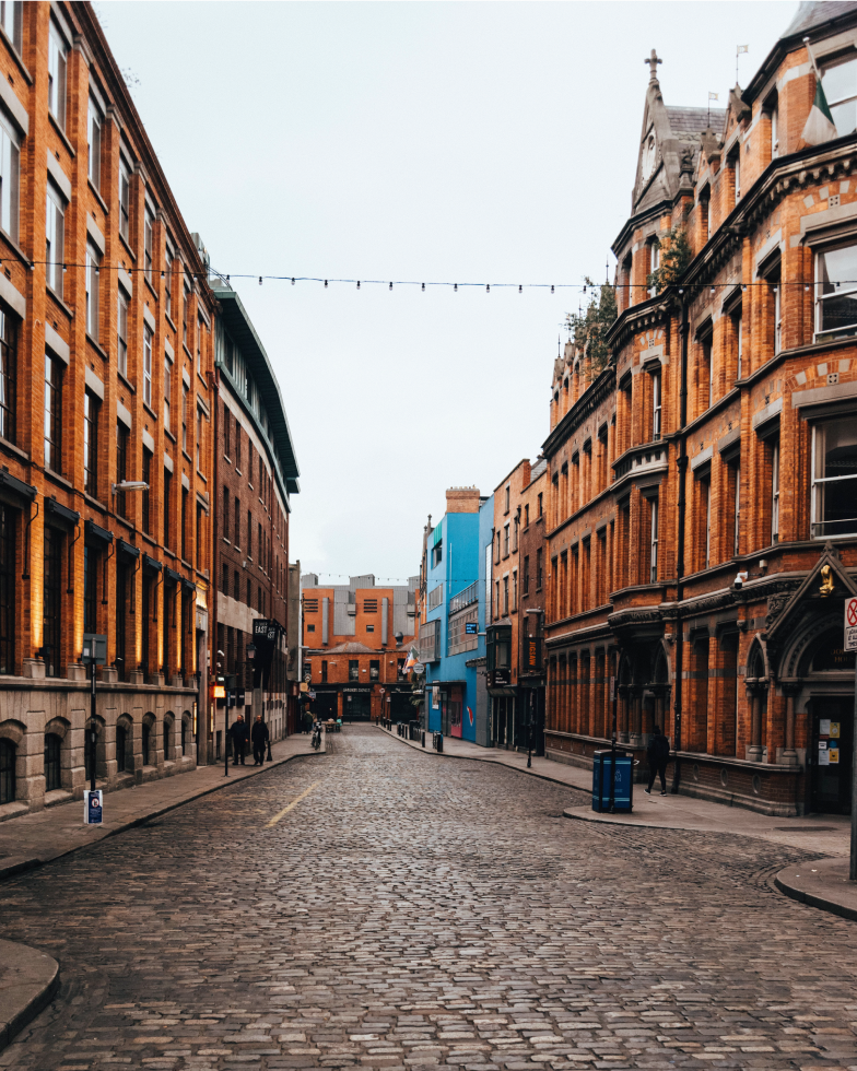 Brown brick buildings frame a cobblestoned street in Dublin.