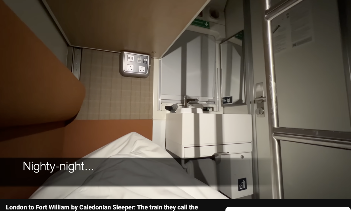 Inside a Caledonian Sleeper train cabin from London to Fort William, showing a bed and compact sink under soft lighting.